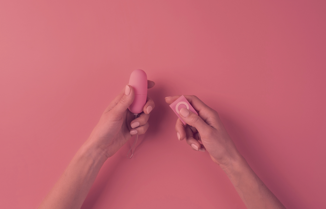 hands holding vibrator and remote control