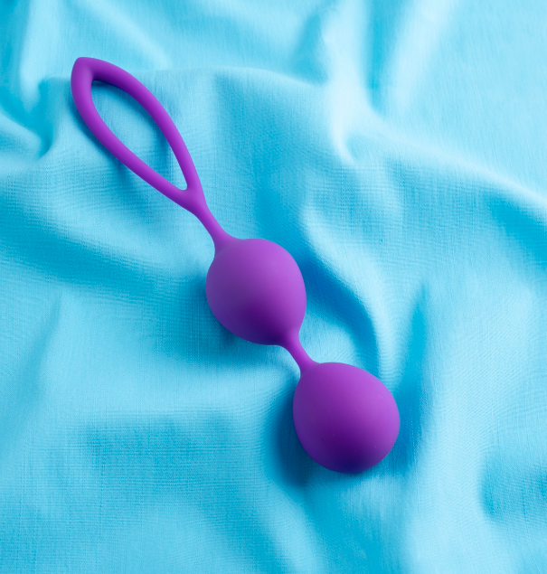 Purple Kegel balls on a light blue background, designed for pelvic floor strengthening and intimate pleasure - IntimateTouch.